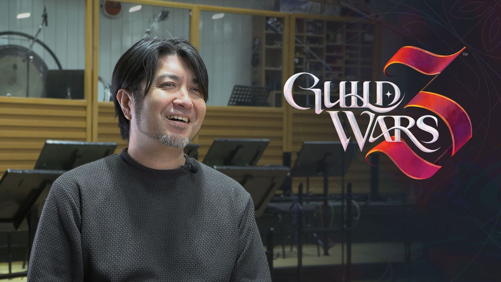 Kazuma Jinnouchi smiles in front of a recording setup